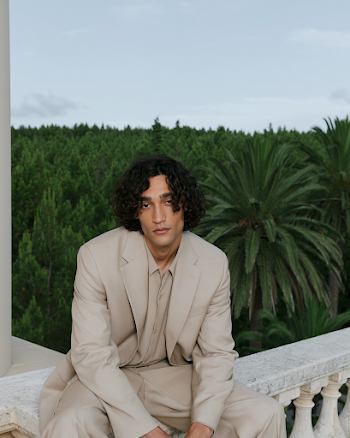 Calm Man in Beige Suit Against Lush Greenery