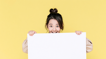 Cheerful Young Woman with Blank Signboard