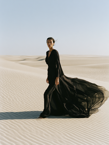 Elegant Woman in Flowing Black Dress in Minimal Desert