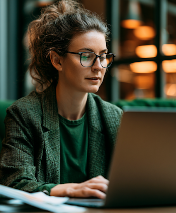 Focused Writer Reviewing Document on Laptop