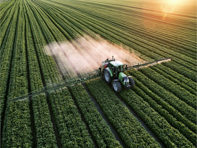 Aerial View of Tractor Spraying Crops in Golden-Hour Light