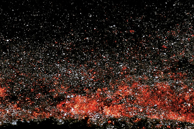 Cosmic Granular Texture: Abstract Macro of Dark Surface with Reflective Particles