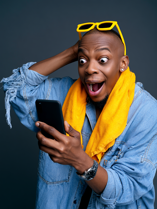 Joyful Young Man with Smartphone in Studio