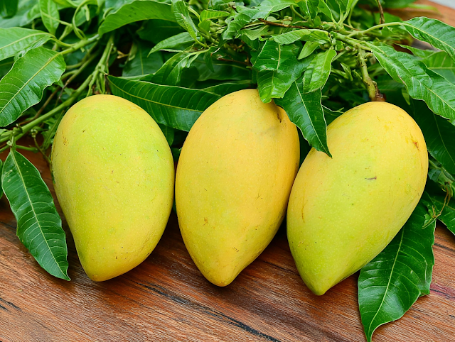 Vibrant Yellow-Green Mangoes on Wooden Surface